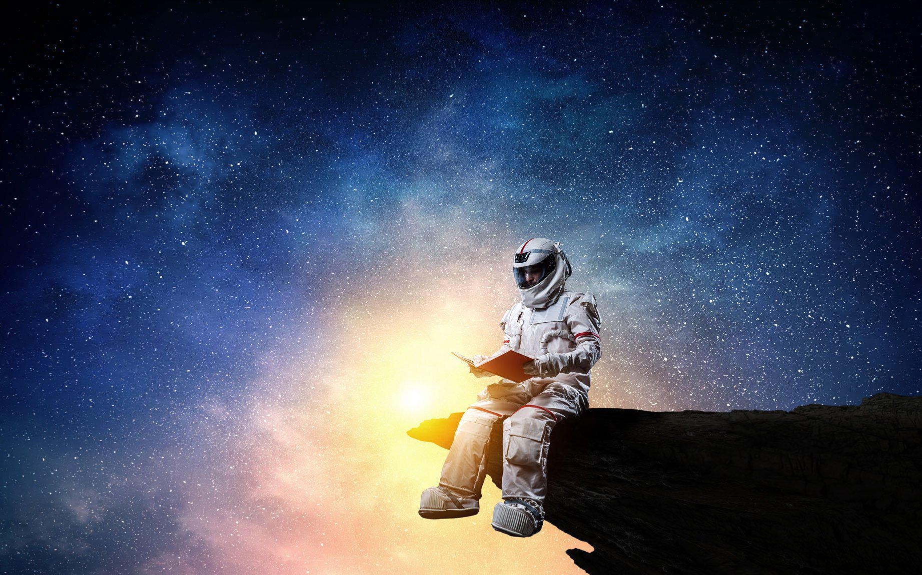 Auf einem Felsvorsprung sitzt ein Astronaut, der ein Buch in der Hand hält. Im Hintergrund ist ein Galaxie in schillernden Farben abgebildet.