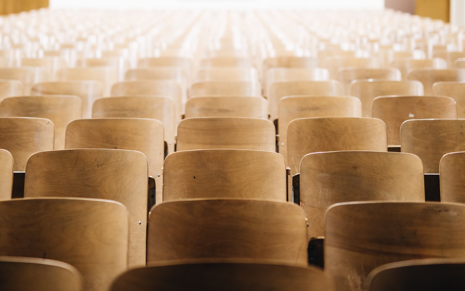 Blick in einen leeren Universitäts-Hörsaal aus Sprecherperspektive, man sieht leere Stuhlreihen.
